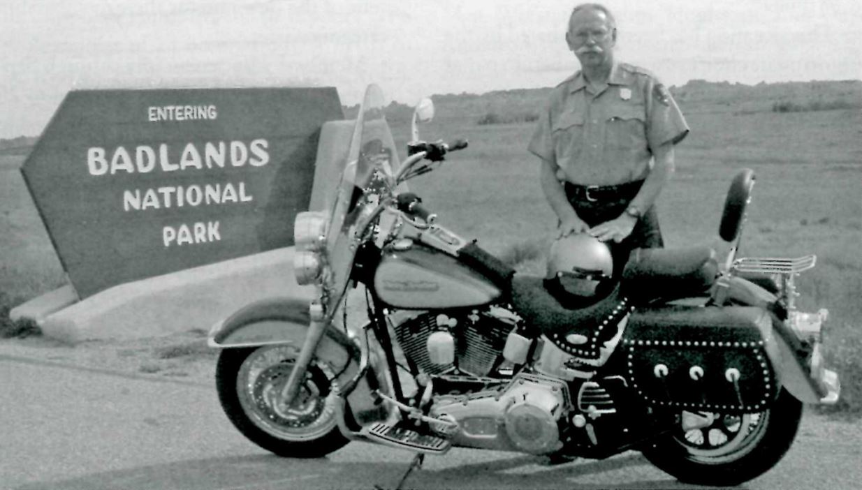 Bill Supernaugh next to his motorcycle at the entrace to Badlands National Park